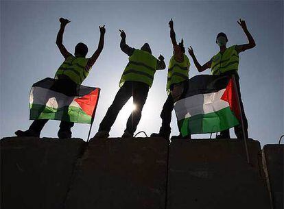 Los activistas palestinos se disponen a derribar un fragmento del muro de Cisjordania.