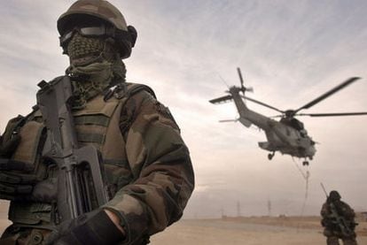 Un soldado de la fuerza internacional desplegada en Afganistán protege el despegue de un helicóptero.