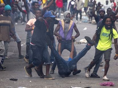 Los manifestantes arrastran el cuerpo de un compañero muerto hacia la policía, durante una protesta en Puerto Príncipe (Haiti).