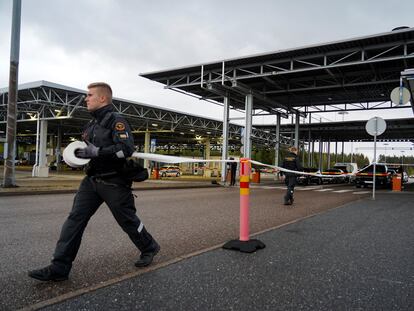 Un guardia coloca una cinta en el cruce fronterizo de Vaalimaa, en Finlandia.