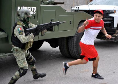 Un soldado del Ejército mexicano apunta su rifle a un hombre que lo acusó de participar en la masacre de Nuevo Laredo