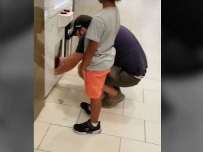 Un hombre usa a una niña pequeña para robar los premios de una máquina expendedora en el centro comercial de Estados Unidos.