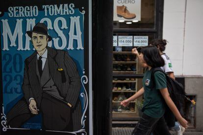 Passersby pass in front of one of Sergio Massa's posters in Buenos Aires. 