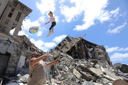 Un palestino juega con una niña junto a los escombros de una vivienda bombardeada, el sábado en Gaza.