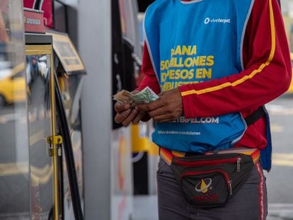 Un trabajador cuenta dinero en una gasolinera Terpel en Cali, Colombia,  en junio de 2023.