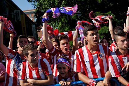 Aficionados esperan la llegada de los jugadores del Atlético de Madrid en la fuente de Neptuno .