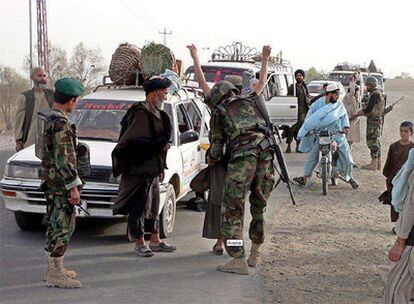 Un soldado afgano cachea a una persona en un control de carretera montado para la búsqueda de los talibanes fugados de la prisión de Kandahar.