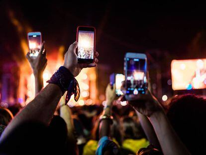 Asistentes a un festival graban con sus móviles.