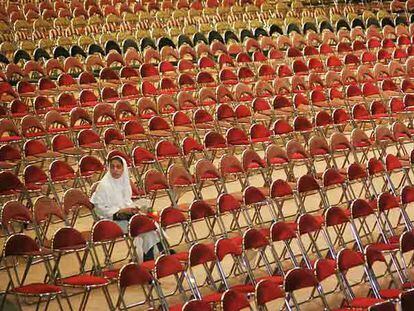 Una estudiante iraní espera en una boda multitudinaria financiada por organizaciones para ayudar a los que no se pueden costear la ceremonia.