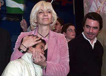 Teófila Martínez abraza a un niño, ayer, en presencia de José María Aznar.