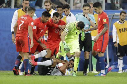 Can protege la pelota rodeado de jugadores chilenos.