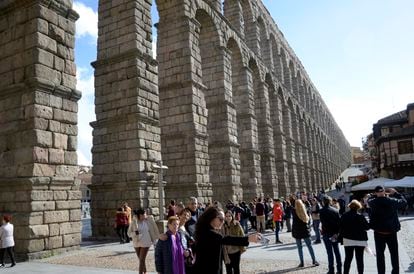 Un grupo de turistas se fotografía delante del acueducto de Segovia.