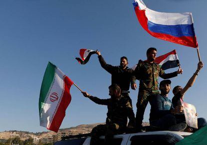Ciudadanos sirios ondean banderas iraníes, rusas y sirias durante una protesta contra el ataque de EE UU.