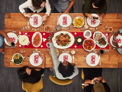 Un grupo de personas celebra una comida de Navidad.