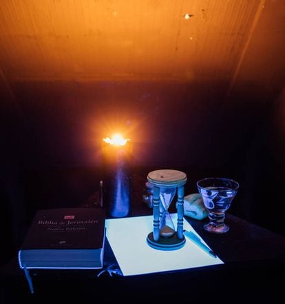 Una vela negra ilumina los elementos sobre la mesa de la "cámara de reflexión" por la que pasan los iniciados en el rito escocés de la masonería.