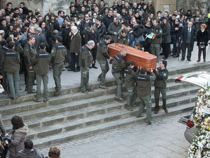 Compañeros de los agentes trasladan el féretro de una de las víctimas en su funeral.