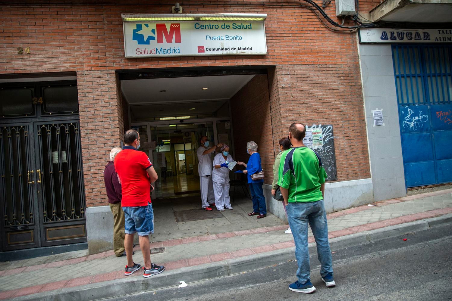 Varios pacientes aguardan ante la puerta del centro de salud Puerta Bonita, de Madrid.