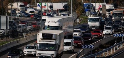 Camiones y otros vehículos en una autopista a su paso por Madrid.