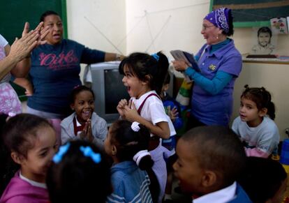 Estudiantes y profesores celebran tras escuchar el discurso transmitido a nivel nacional por el presidente de Cuba, Raúl Castro sobre la restauración de las relaciones con los Estados.