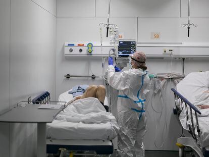 Una sanitaria junto a un paciente crítico en el Hospital de Mar.