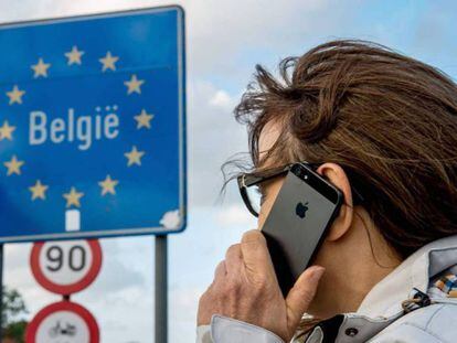 Una mujer usa su móvil en la frontera franco-belga.