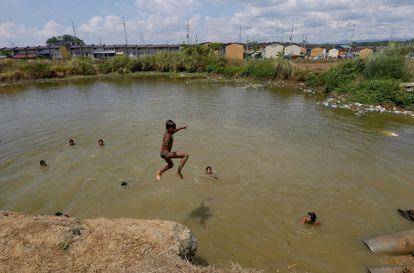 Un grupo de niños nadan en un pantano dentro del proyecto de vivienda del gobierno filipino para la policía y las fuerzas armadas en la provincia de Bulacan, a unos 50 kilómetros al norte de Manila, Filipinas.