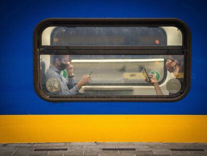 Dos viajeros revisan sus móviles en la Estación Central de Utrecht (Países Bajos), el 10 de noviembre de 2022.