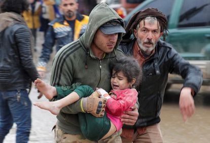 Un hombre trasladaba a una niña herida durante el terremoto, con epicentro en Turquía, en Jandaris (Siria).