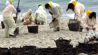 Cientos de voluntarios de toda España recogen el fuel de la playa de Figueiras, de las Islas Cíes, afectadas por el vertido del petrolero Prestige.