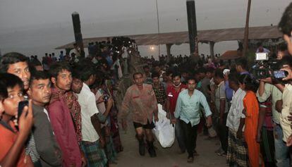 El equipo de rescate carga el cuerpo de un pasajero tras el hundimiento de un barco en Bangladesh.