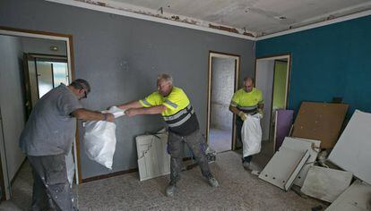 D'esquerra a dreta, Vicente, Juan i Francisco treballen en la rehabilitació d'un pis per a ús social.