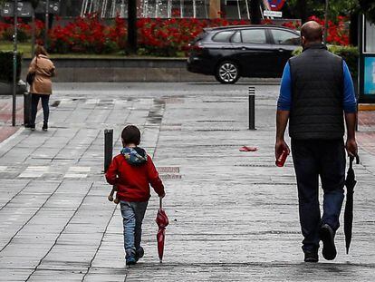Un hombre pasea junto a un niño en Sevilla, este lunes. 