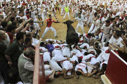 Uno de los toros saltando la barrera humana para entrar en la plaza de Toros durante el segundo día de San Fermín.