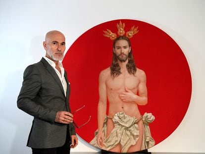 El artista Salustiano García posa junto a su cartel para la Semana Santa sevillana.