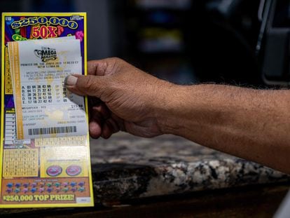 Un cliente muestra su billete de lotería comprado en una gasolinera CITGO el 10 de enero de 2023 en Austin, Texas.