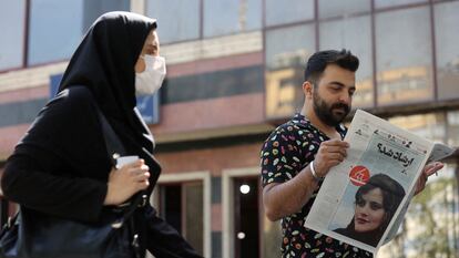 Un hombre leía el lunes en Teherán un periódico en el que figura la fotografía de Mahsa Amini.