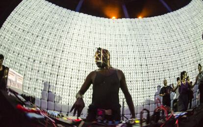 El DJ Dave Watts ante la pantalla de 18 metros de largo y 6 metros de alto construida con bidones de 25 litros sobre la cual se proyecta 'video mapping'.