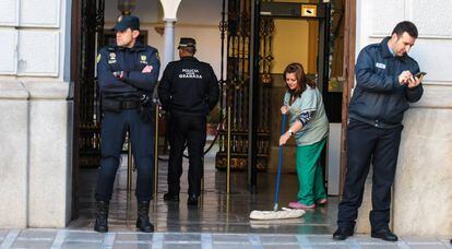 Dos agentes de la polic&iacute;a de Granada y funcionarios, en el Ayuntamiento de la ciudad.