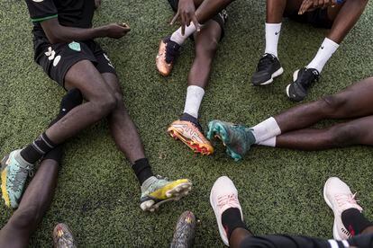 Jugadores del Espoirs de Guediawaye juvenil descansan tras un entrenamiento en el estadio municipal Ibrahima Boye, en Guediawaye.