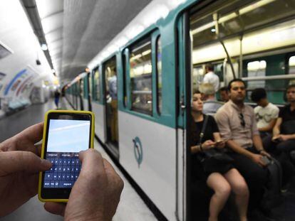 Un hombre sujeta un m&oacute;vil en el metro de Par&iacute;s