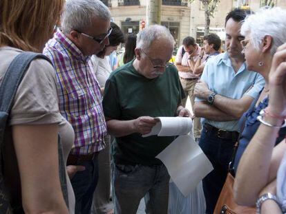 Empleados del Incas&ograve;l leen el listado de despedidos en el ERE, en junio pasado. 