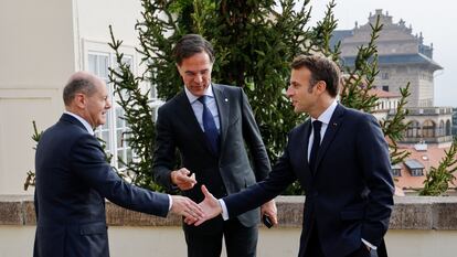 El canciller alemán, Olaf Scholz estrecha la mano al francés Emmanuel Macron en frente de su homólogo de Países Bajos, Mark Rutte en el encuentro informal de la UE en Praga este viernes.