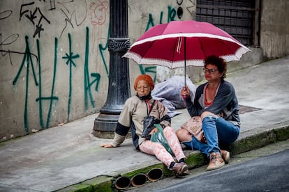 Celine de Luz Siqueira, (81 anos) charla con Elisabete Bezerra sobre la acera, mientras esperan el plato fuerte.