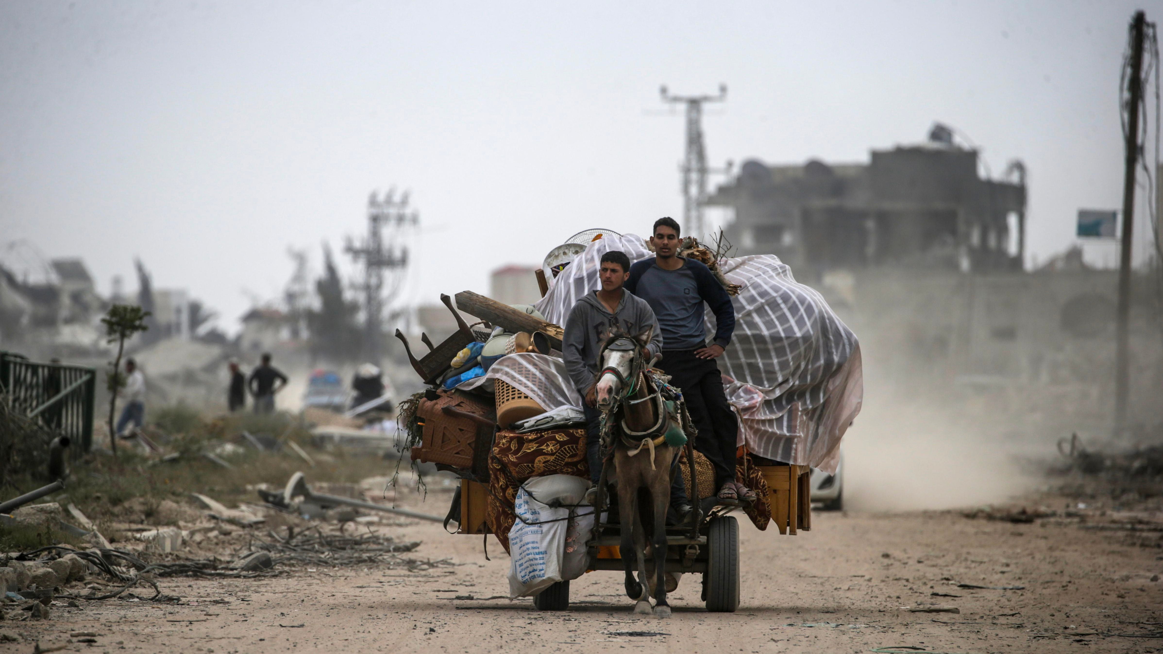 Khan Younis (---), 08/04/2024.- Palestinians ride on a cart loaded with their belongings past the rubble of destroyed houses following the Israeli military operation in Khan Younis, southern Gaza Strip, 08 April 2024. Displaced Palestinians have started to return to Khan Younis, after the Israeli army announced on 07 April its partial withdrawal from parts of the southern Gaza Strip. Since 07 October 2023, up to 1.9 million people, or more than 85 percent of the population, have been displaced throughout the Gaza Strip, some more than once, according to the United Nations Relief and Works Agency for Palestine Refugees in the Near East (UNRWA), which added that most civilians in Gaza are in 'desperate need of humanitarian assistance and protection'. EFE/EPA/MOHAMMED SABER 
