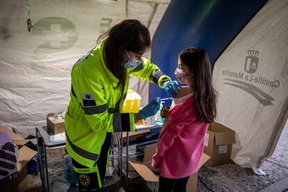 Una trabajadora sanitaria administra la primera dosis de la vacuna contra la covid-19 a una niña en Castilla-La Mancha, en diciembre de 2021.