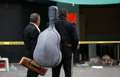 Dos mariachis observan el lugar de la plaza Garibaldi donde la semana pasada fueron asesinadas cinco personas