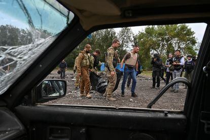 Un grupo de agentes de policía trasladan el cuerpo de una persona asesinada por el ataque ruso.