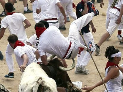 Un mozo es zarandeado por uno de los toros en la entrada de la plaza.