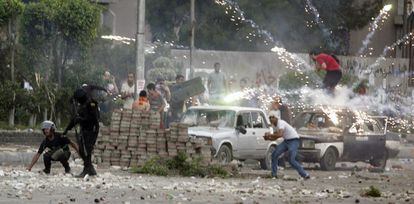 Fuegos artificiales junto a los policías y manifestantes anti Morsi.