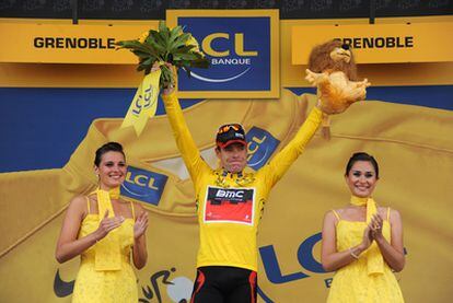 Cadel Evans recibe el maillot amarillo en el podio de Grenoble.